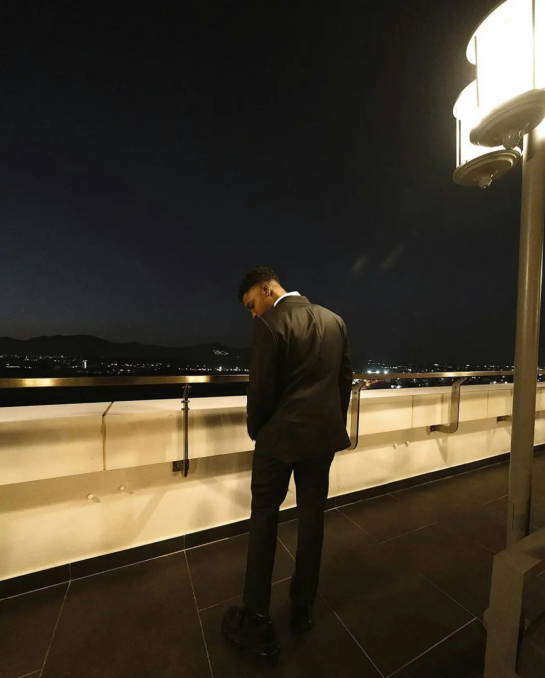 Protection officer overlooking the city from a venue terrace at night